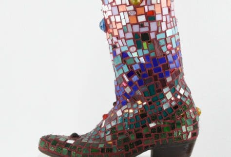 Cowboy boot covered in multi colored mosaic tiles